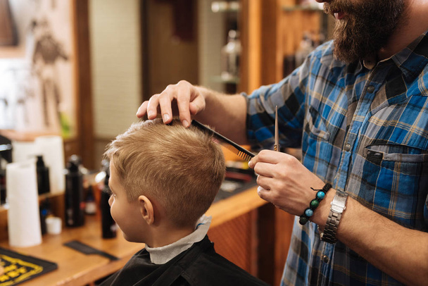 barber doing the haircut for child - Fotoğraf, Görsel