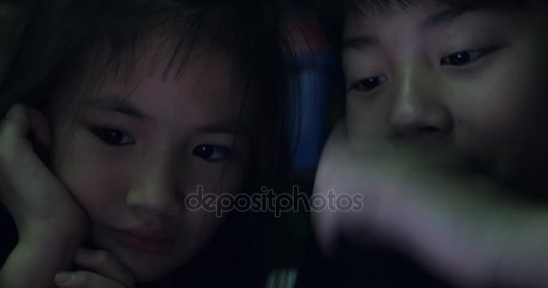 Asiática familia padre hija y el hijo ver vídeo desde tablet ordenador
 . - Metraje, vídeo