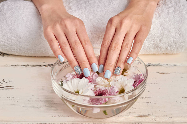 Spa for hands. Delicate flowers in a glass bowl.  - Photo, Image