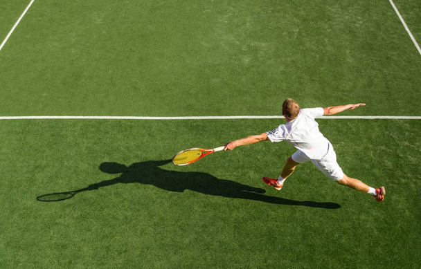 Sportive man playing tennis - Фото, изображение