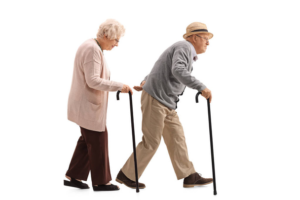 Elderly man and an elderly woman with canes walking - Fotó, kép