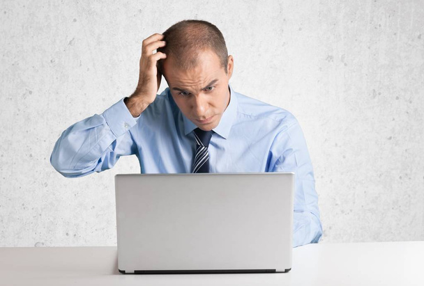 Stressed businessman with laptop - 写真・画像