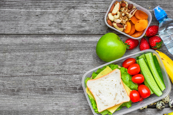Sandviç, yumurta ve taze sebze, meyve, fındık ve su şişe ile sağlıklı öğle yemeği kutuları - Fotoğraf, Görsel