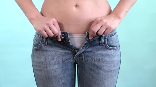 Женщина пытается закрыть слишком узкие синие джинсы. Живот жир и время, чтобы сесть на диету
 - Кадры, видео