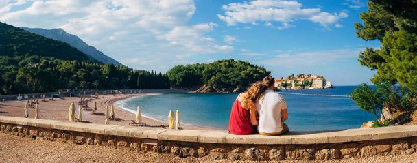 Una joven pareja abraza y mira a la isla de Sveti Stefan
 - Foto, imagen