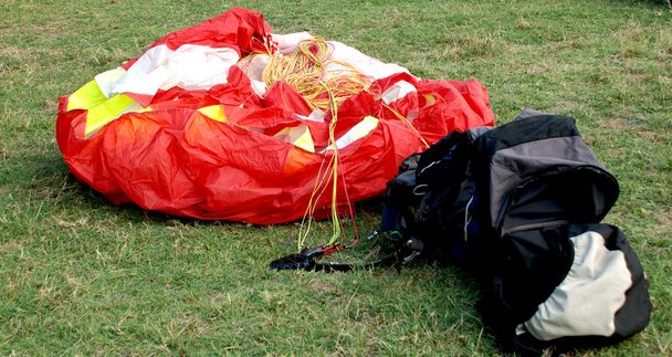 Parapente vermelho e sua bolsa vazia
 - Foto, Imagem