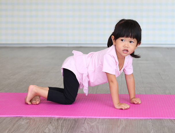 Cute toddler girl practicing yoga and doing exercise - Fotografie, Obrázek