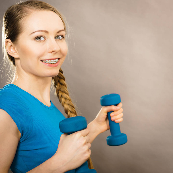 Teenage woman working out at home with dumbbell - Fotó, kép