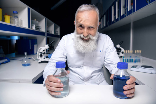 scientist holding bottles with reagents - Foto, imagen