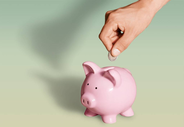 putting coin in pig moneybox - Fotografie, Obrázek