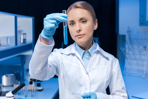 laboratory technician looking at tube with reagent - Photo, Image