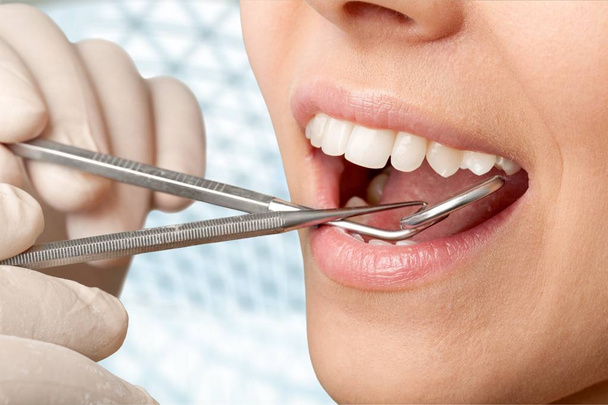 Γυναικεία δόντια και οδοντίατρος καθρέφτης στόματος - Φωτογραφία, εικόνα