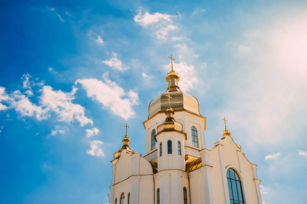 Церковь с золотыми куполами на голубом небе с облаками
. - Фото, изображение