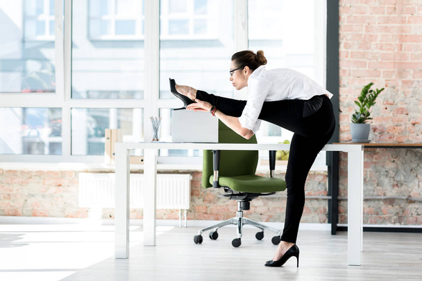 Calm woman making exercise in office - Фото, изображение