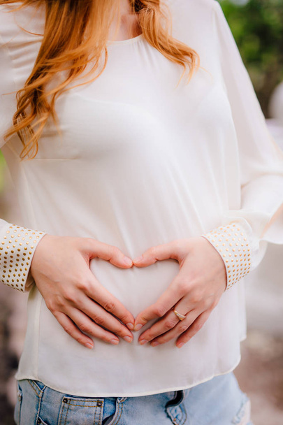 Donna incinta che tiene la pancia con le mani
 - Foto, immagini
