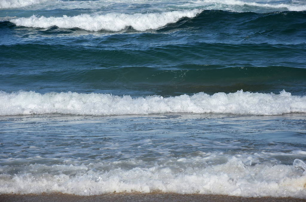 Espuma de agua de las olas aplastándose en la orilla
 - Foto, imagen