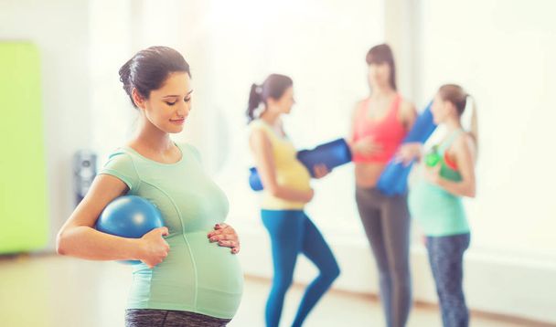 happy pregnant woman with ball in gym - Photo, Image