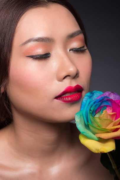 woman holding colorful rose - 写真・画像