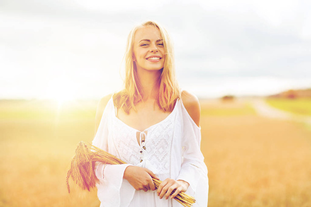 happy young woman with spikelets on cereal field - Foto, Imagem