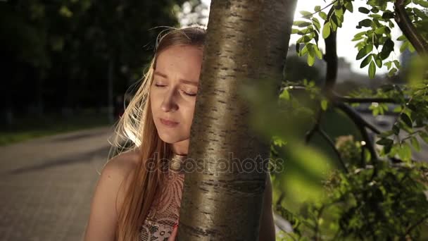 Γυναίκα απελπιστεί κλίνοντας το κεφάλι της σε κορμό δέντρου - Πλάνα, βίντεο