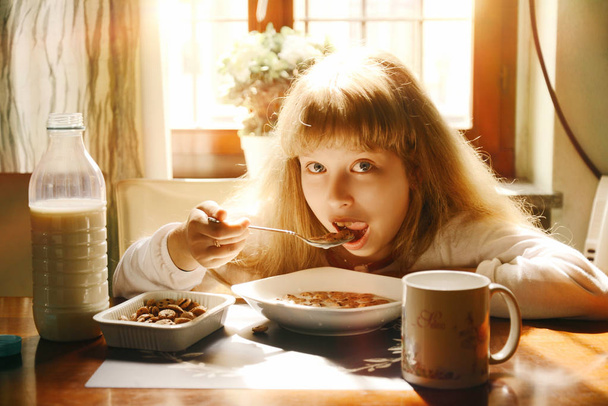 menina feliz em casa sorrindo tomando café da manhã
 - Foto, Imagem