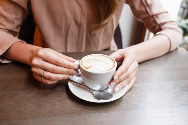 Симпатичная девушка в кафе у окна с улыбкой кофе
 - Фото, изображение