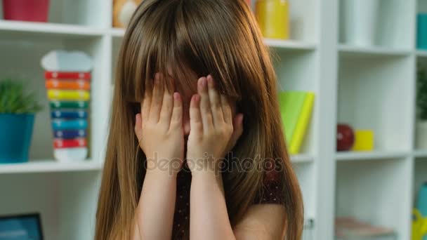 Cute little girl covers her face with hands. Playing hide and seek, peek a boo. Close up - Footage, Video