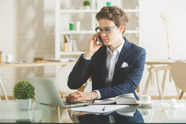 Businessman on the phone using laptop - Фото, изображение