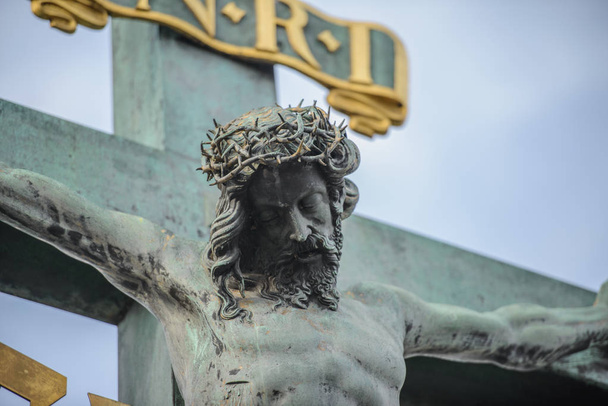Jesus Christ sculpture on the cross crucifix on dramatic sky background - Photo, Image
