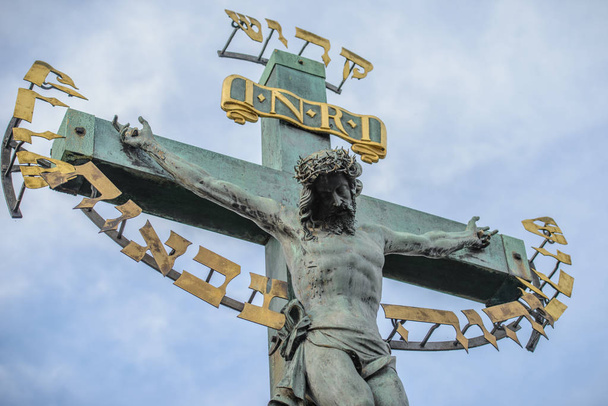 Jesus Christ sculpture on the cross crucifix on dramatic sky background - Photo, Image
