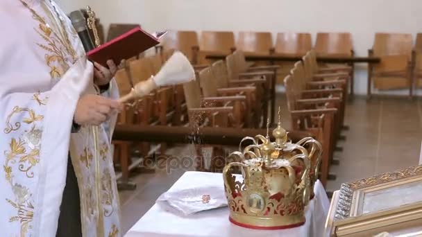 Ιερέας ευλογεί και ψεκασμού νερού σε δύο ροδέλες - Πλάνα, βίντεο