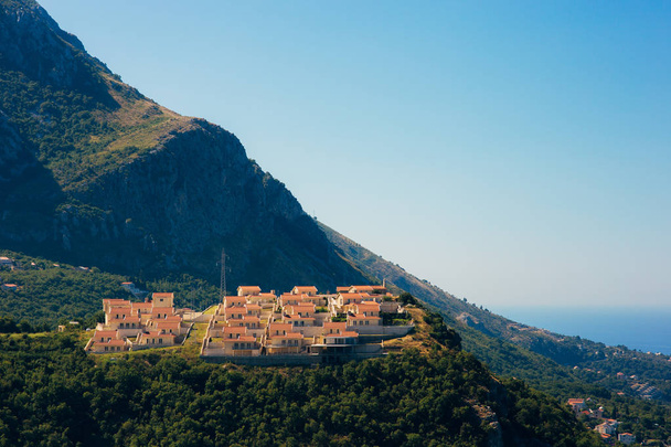 Village on the mountain in Montenegro over the island of Sveti Stefan. - Fotó, kép