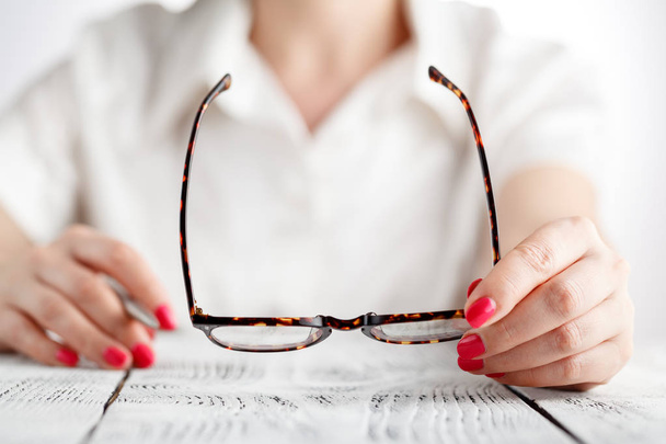 close-up of female optician hands holding eyeglasses - Foto, afbeelding
