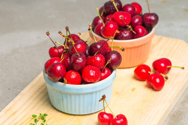 Red ripe cherries in ceramic bowls - Φωτογραφία, εικόνα