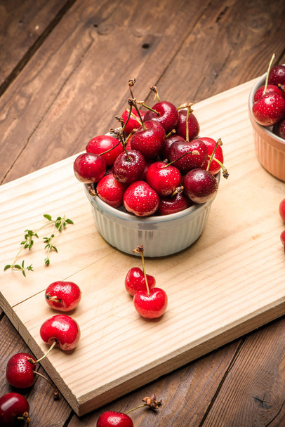 Red ripe cherries in ceramic bowls - Valokuva, kuva