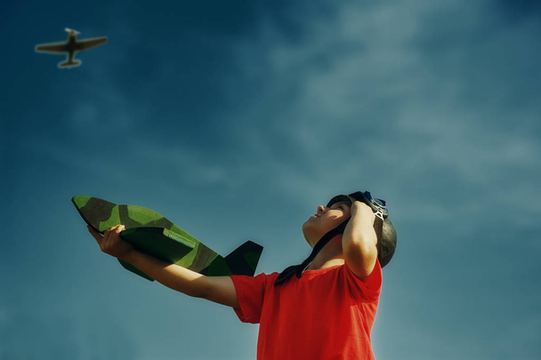 Un niño feliz jugando con un avión de juguete. Un sueño de ser piloto
 - Foto, Imagen