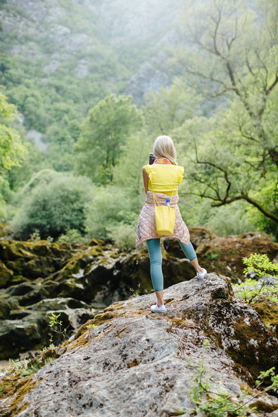 vrouw met rugzak reizen berg rivier - Foto, afbeelding