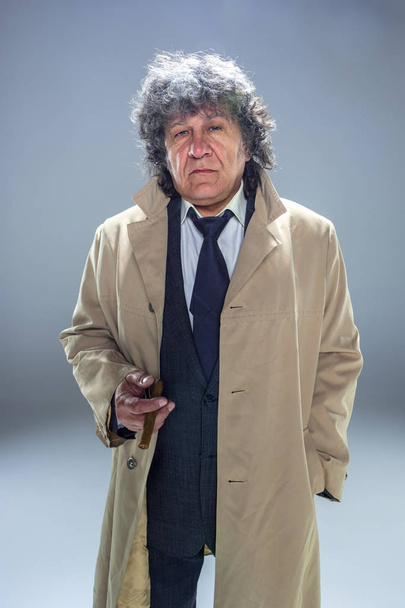 The senior man with cigar as detective or boss of mafia on gray studio background - Foto, afbeelding