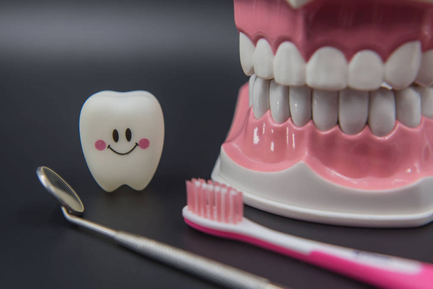 Leuke speelgoed tanden in de tandheelkunde op een zwarte achtergrond model - Foto, afbeelding