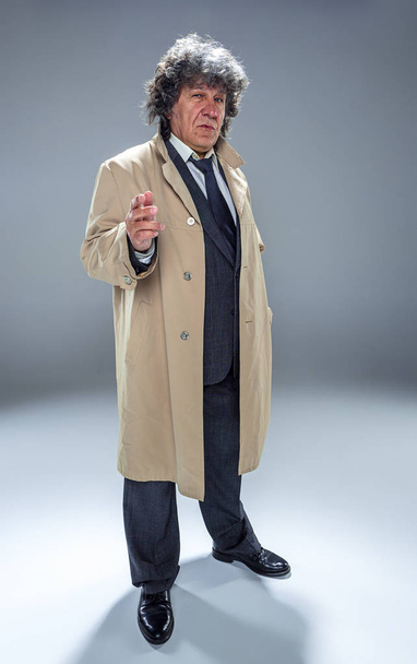 The senior man as detective or boss of mafia on gray studio background - 写真・画像