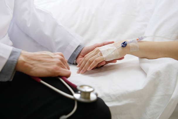 Medico forare la mano del paziente e confortarla
 - Foto, immagini
