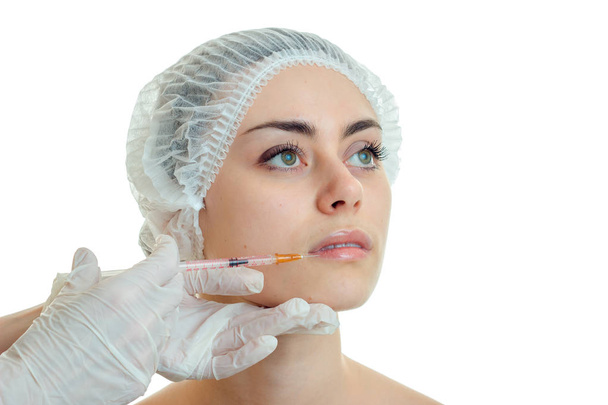o rosto de uma bela jovem em Cap médica, onde o esteticista entra em close-up injeção
 - Foto, Imagem