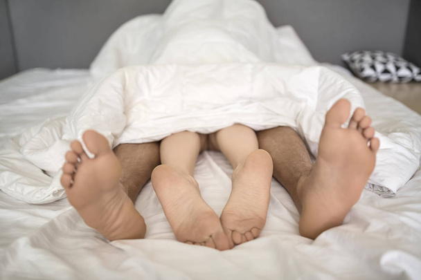 Legs of lovers under blanket - Fotoğraf, Görsel