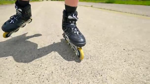 Mans gambe pattinaggio a rotelle sull'asfalto. Vista da vicino per un rapido movimento degli stivali in linea
. - Filmati, video