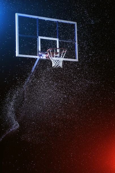 Баскетбольное кольцо изолировано на черном. Баскетбольная арена под дождем. Освещение смешанными цветовыми огнями
. - Фото, изображение