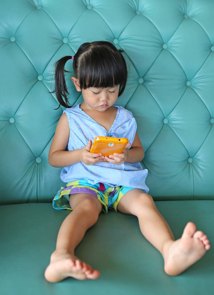 child girl using smart phone on vintage sofa. asian child girl - Fotografie, Obrázek