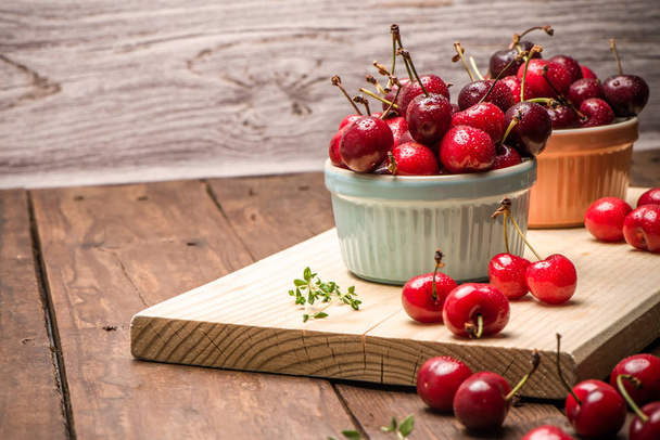Red ripe cherries in ceramic bowls - Foto, Bild