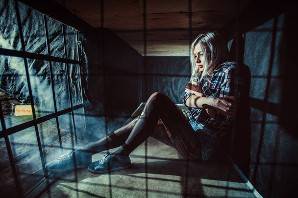 Donna bionda spaventata nella gabbia buia
. - Foto, immagini