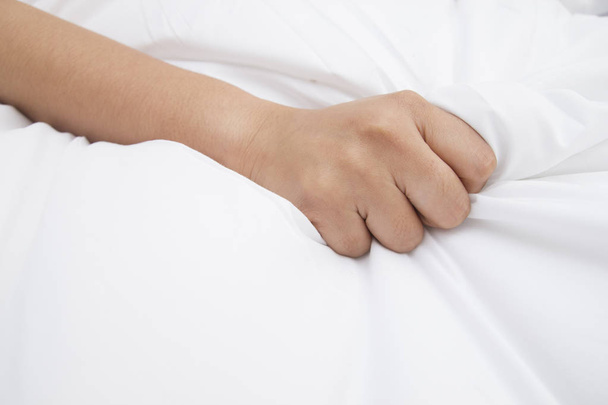 рука женщины тянет белые простыни в экстазе, оргазм
. - Фото, изображение