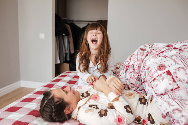 Little girl laughing in bedroom - 写真・画像